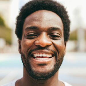 happy-african-man-smiling-at-camera-inside-ba-1.jpg